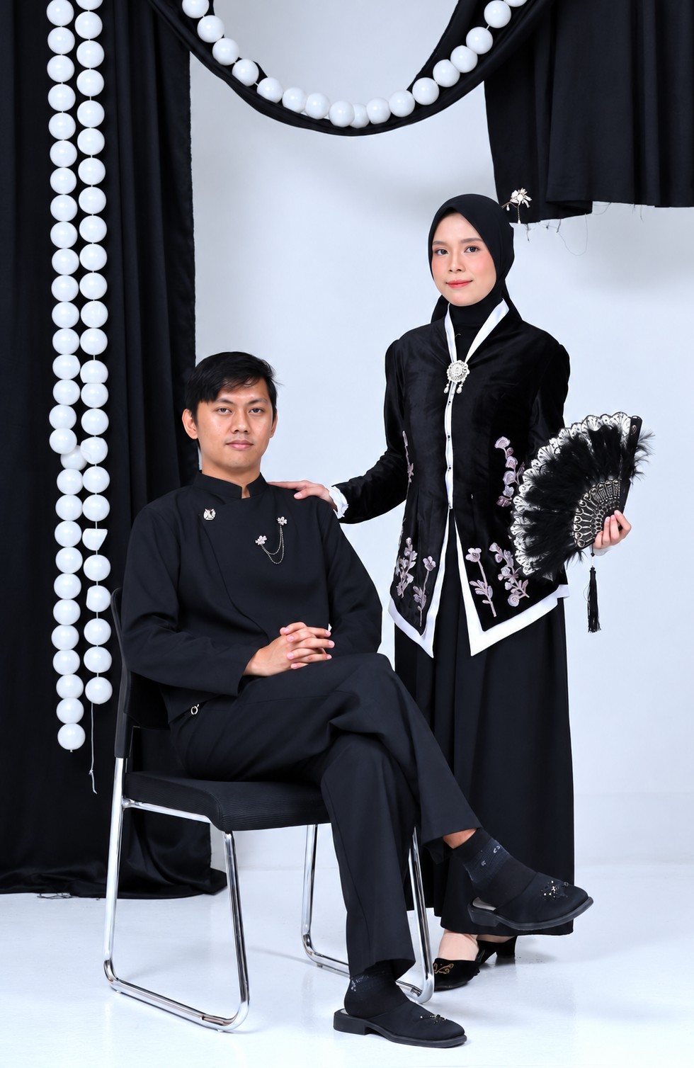 Busana Jawa hitam di antara tirai dan mutiara